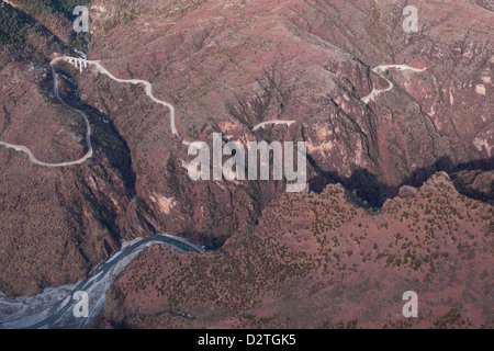 LUFTAUFNAHME. Kurvenreiche Straße über dem Fluss Var in einer Landschaft aus rotbraunem Pelitgestein. Guillaumes, Daluis Gorge, das Hinterland der französischen Riviera, Frankreich. Stockfoto