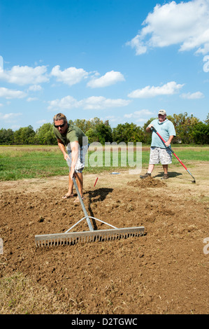 Männer Boden Rechen, einen Garten zu Pflanzen Stockfoto