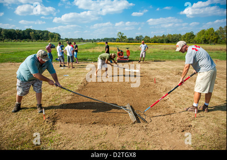 Gruppe von Menschen Boden Rechen, einen Garten zu Pflanzen Stockfoto