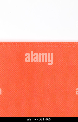 Hochauflösendes Foto von orange Kunststoffgewebe mit Karomuster und zwei gestrichelte Linien entlang der Kante Stockfoto