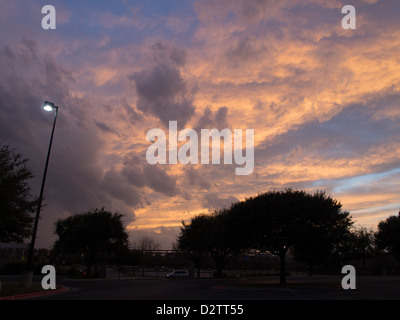 Lila und rosa flauschigen Wolken über einen Parkplatz bei Sonnenuntergang Stockfoto