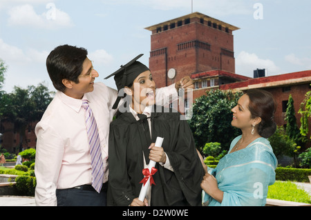 Mann einen Autoschlüssel zu seiner Tochter nach seinem Erfolg Stockfoto