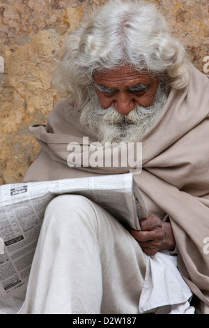 Indien, Rishikesh. Bärtiger alten Mann Hindi Zeitung lesen. Stockfoto