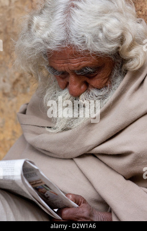 Indien, Rishikesh. Bärtiger alten Mann Hindi Zeitung lesen. Stockfoto