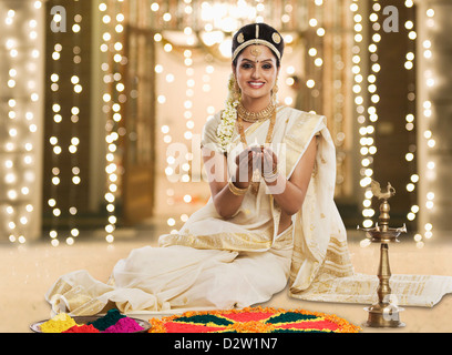 Indische Frau in traditioneller Kleidung mit einer Öllampe auf Durga Puja Festival beten Stockfoto