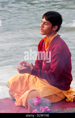 Indien, Rishikesh. Junger Mönch beten Abendgebet (Aarti) im Parmarth Niketan Ashram, an den Ufern des Ganges (Ganga). Stockfoto