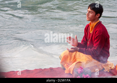 Indien, Rishikesh. Junger Mönch beten Abendgebet (Aarti) im Parmarth Niketan Ashram, an den Ufern des Ganges (Ganga). Stockfoto