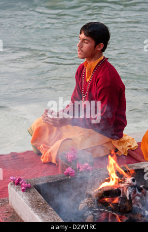 Indien, Rishikesh. Junger Mönch beten Abendgebet (Aarti) im Parmarth Niketan Ashram, an den Ufern des Ganges (Ganga). Stockfoto