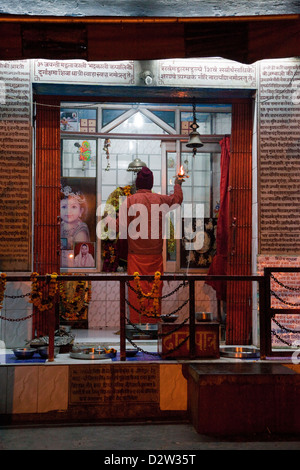 Indien, Rishikesh. Hindu Priester beten am frühen Morgen in einem Schrein. Stockfoto