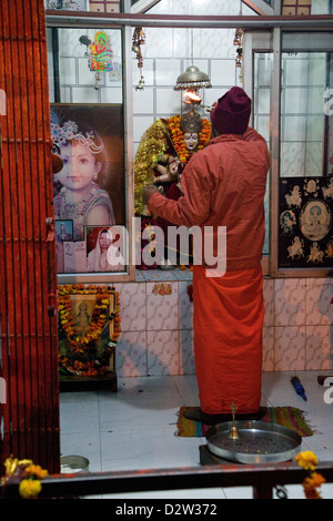 Indien, Rishikesh. Hindu Priester beten am frühen Morgen in einem Schrein. Stockfoto