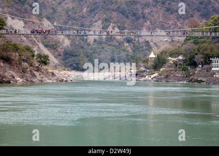 Indien, Rishikesh. Hängebrücke verbindet die beiden Ufer. Menschen und Maultiere überqueren. Stockfoto