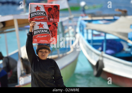 Ein Indonesierin offload Kästen Bier von kleinen Booten in der Coral Insel Gili Trawangan; Lombok, Indonesien. Stockfoto