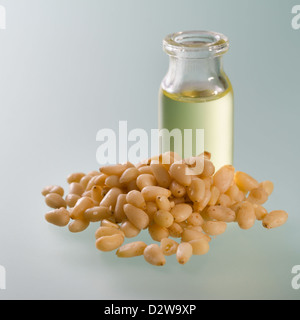 Geöffnete Flasche Zedernöl und Nüssen auf weichem Untergrund Stockfoto