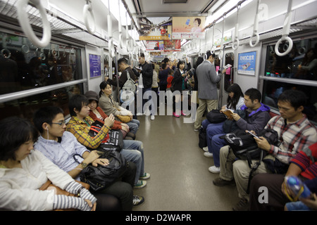 Japanische Passagiere sitzen in der u-Bahn, Tokyo, Japan Stockfoto