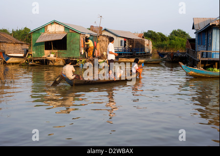 Chong Kneas, Kambodscha, Vater mit seinen Kindern vor einem Longtail-Boot Stockfoto