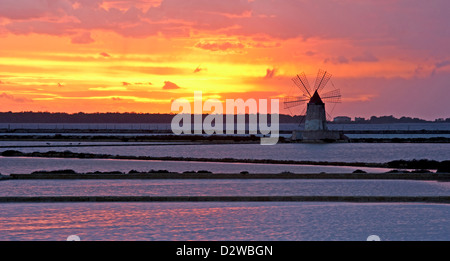 Windmühle in Infersa Salinen bei Sonnenuntergang in Marsala, Sizilien, Italien. Stockfoto