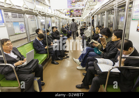 Japanische Passagiere sitzen in der u-Bahn Weg zur Arbeit am frühen Morgens, Tokyo, Japan Stockfoto