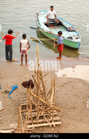 Kinder spielen am Ufer des Flusses Ganges, Varanasi, Indien Stockfoto