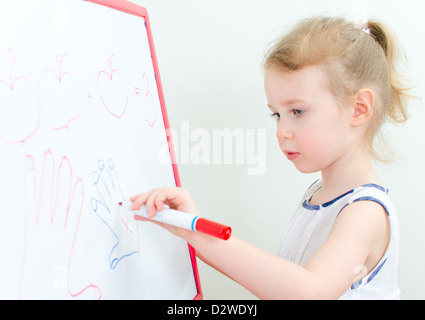 Hübsches kleines Mädchen mit roten Markierung auf einem Whiteboard schreiben Stockfoto