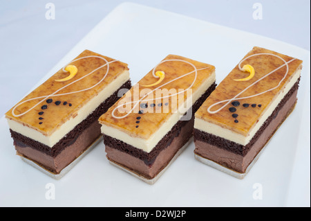 Drei Portionen Scheiben von Schokolade Biskuit auf eine Platte isoliert auf weiss Stockfoto