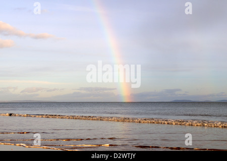Regenbogen über dem Meer bei Sonnenuntergang Tenby South Beach Pembrokeshire Wales Cymru UK GB Stockfoto