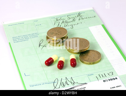 NHS-Rezept mit Pfund-Münzen und Medikamenten zur Veranschaulichung des Konzepts der Kosten für verschreibungspflichtige Arzneimittel, UK Stockfoto