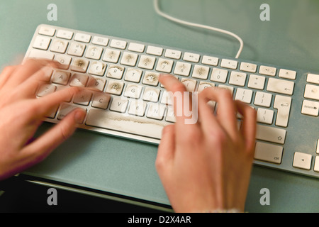 Verschwommene Finger Tippen auf einer schmutzigen Computertastatur Stockfoto
