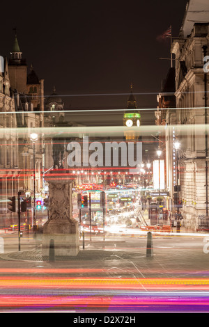 Verkehr Hauptverkehrszeit am Trafalgar Square in London, Vereinigtes Königreich, mit dem internationalen Wahrzeichen Big Ben im Hintergrund. Stockfoto