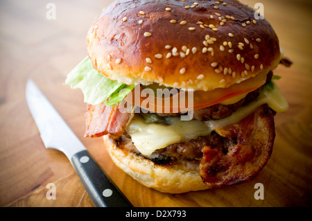 Doppel-Käse - zwei Burger, geschichtet mit Käse, Speck, Tomaten, Salat, Gurke, Zwiebel und Burger-Sauce Stockfoto