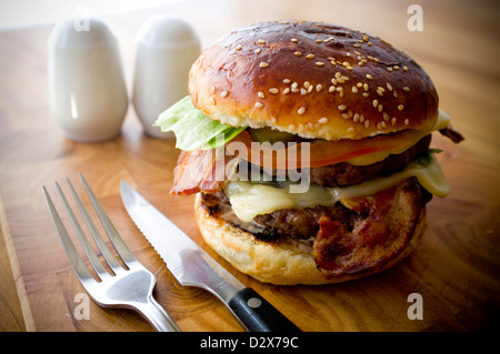 Doppel-Käse - zwei Burger, geschichtet mit Käse, Speck, Tomaten, Salat, Gurke, Zwiebel und Burger-Sauce Stockfoto