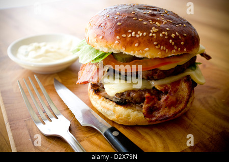 Doppel-Käse - zwei Burger, geschichtet mit Käse, Speck, Tomaten, Salat, Gurke, Zwiebel und Burger-Sauce Stockfoto