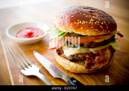 Doppel-Käse - zwei Burger, geschichtet mit Käse, Speck, Tomaten, Salat, Gurke, Zwiebel und Burger-Sauce Stockfoto