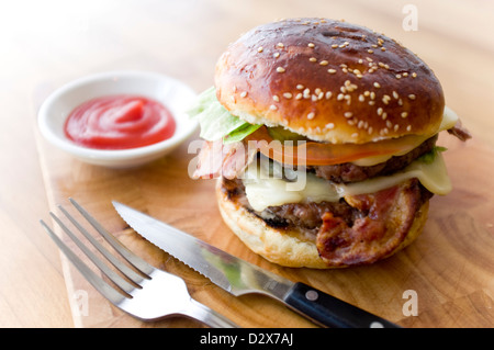 Doppel-Käse - zwei Burger, geschichtet mit Käse, Speck, Tomaten, Salat, Gurke, Zwiebel und Burger-Sauce Stockfoto