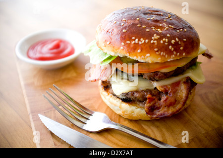 Doppel-Käse - zwei Burger, geschichtet mit Käse, Speck, Tomaten, Salat, Gurke, Zwiebel und Burger-Sauce Stockfoto