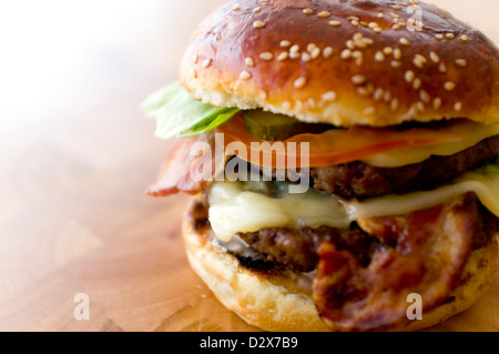 Doppel-Käse - zwei Burger, geschichtet mit Käse, Speck, Tomaten, Salat, Gurke, Zwiebel und Burger-Sauce Stockfoto