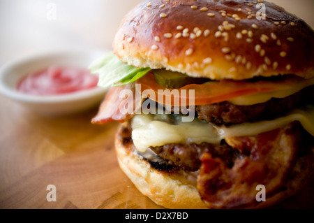 Doppel-Käse - zwei Burger, geschichtet mit Käse, Speck, Tomaten, Salat, Gurke, Zwiebel und Burger-Sauce Stockfoto