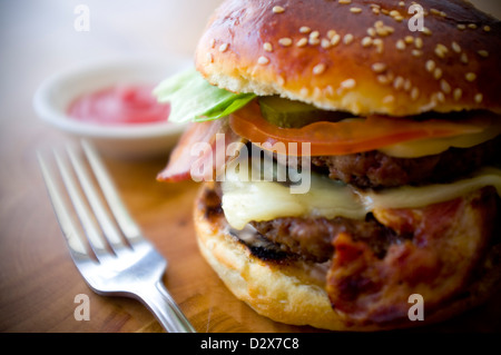 Doppel-Käse - zwei Burger, geschichtet mit Käse, Speck, Tomaten, Salat, Gurke, Zwiebel und Burger-Sauce Stockfoto