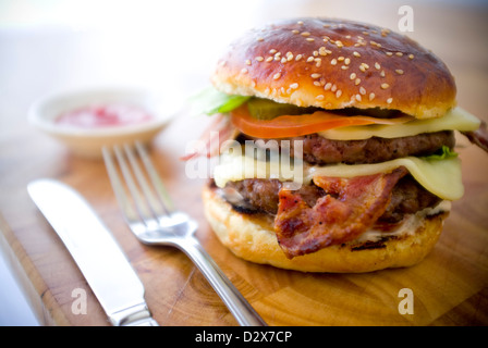 Doppel-Käse - zwei Burger, geschichtet mit Käse, Speck, Tomaten, Salat, Gurke, Zwiebel und Burger-Sauce Stockfoto