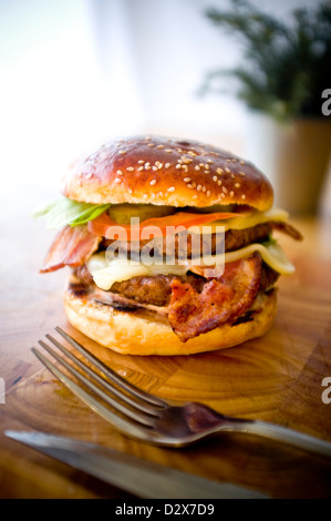 Doppel-Käse - zwei Burger, geschichtet mit Käse, Speck, Tomaten, Salat, Gurke, Zwiebel und Burger-Sauce Stockfoto