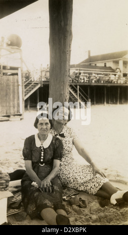 Ca. 1900 s Foto, zwei ältere Frauen, vielleicht Schwestern unter einem Pier Strand picknicken. Stockfoto