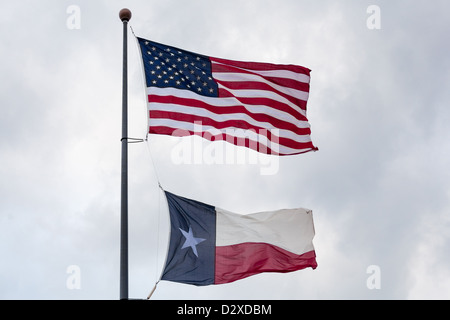 Die Flaggen der Vereinigten Staaten von Amerika und der Zustand von Texas auf einer Fahnenstange fließt in den Wind. Stockfoto