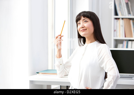 Glückliche junge Geschäftsfrau im Büro Stockfoto