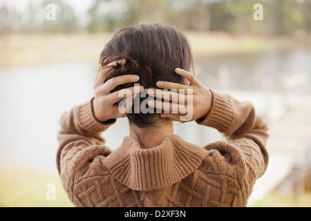 Frau mit Haaren in Händen am Seeufer Stockfoto