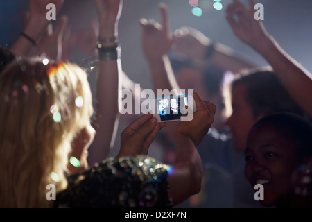 Frau mit Kamera-Handy fotografieren Freunde auf die Tanzfläche der Disco Stockfoto