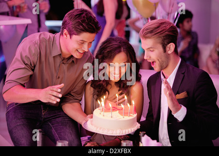 Freunde mit Geburtstagstorte in Nachtclub Stockfoto