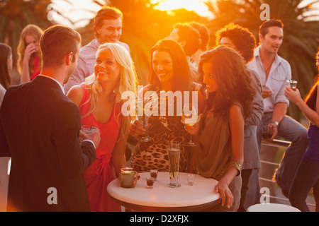 Lächelnden Freunde tranken Cocktails auf sonnigen Balkon Stockfoto