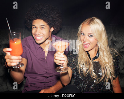 Porträt von begeisterten paar, toasten, Cocktails in Nachtclub Stockfoto