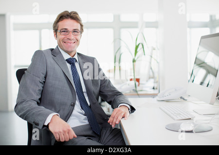 Porträt von lächelnden Geschäftsmann am Schreibtisch Stockfoto