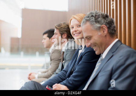 Porträt von lächelnden Geschäftsfrau mit Geschäftsleute sitzen Stockfoto