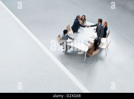 Unternehmer treffen Händeschütteln über Tisch Stockfoto